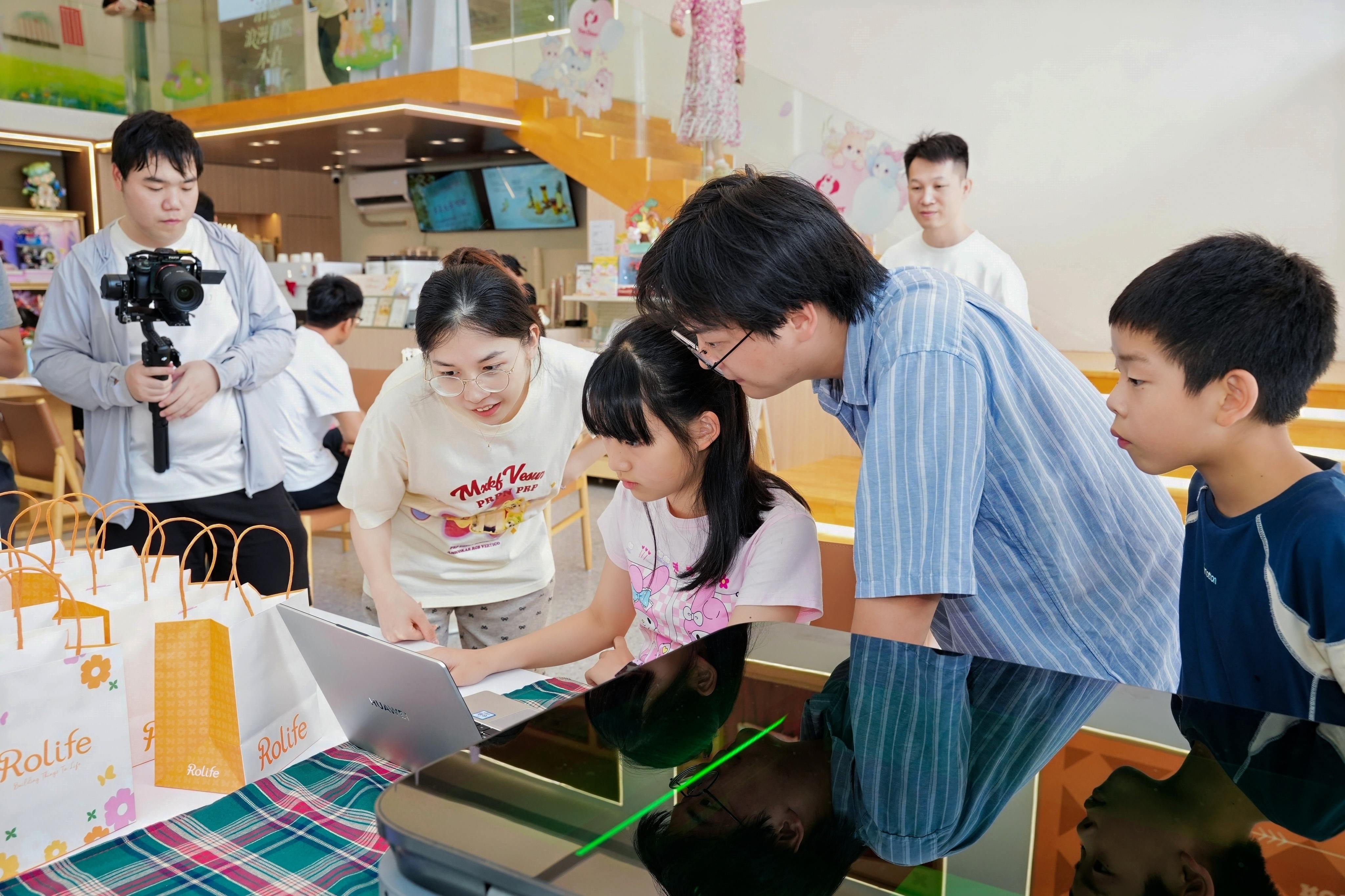 Families watching the Focalab laser machine at work
